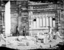 University under construction, stoneworker in front of the window of main building.